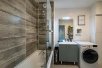 a bathroom with a shower and a washing machine at Voltaire in Toulouse