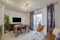 a living room with a table and chairs and a television at Voltaire in Toulouse