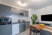 a kitchen and dining room with a table and a television at Voltaire in Toulouse