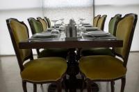 Una mesa larga con sillas alrededor y vasos encima. en Fiori Hotel, en Erbil