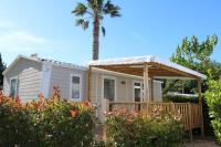une petite maison avec un palmier en arrière-plan dans l&#39;établissement Camping le Village de Florine, à Coëx