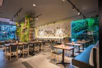 Um restaurante com mesas e cadeiras e uma grande janela. em Holiday Inn Express Bangkok Sathorn by IHG em Banguecoque