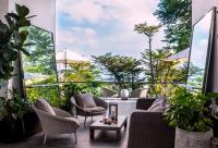 a patio with chairs and a table and some plants at Capella Singapore in Singapore