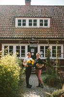 two women holding flowers in front of a building at Vallåsens Värdshus STF Hostel in Våxtorp