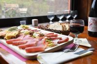 einen Teller mit Lebensmitteln auf einem Tisch mit Weingläsern in der Unterkunft Auberge Cevenole in Valleraugue