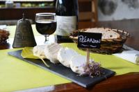 einen Tisch mit einem Glas Wein und einem Teller Essen in der Unterkunft Auberge Cevenole in Valleraugue