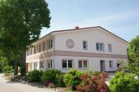 a white building with flowers in front of it at Cafe und Pension Blohm in Greifswald