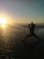 a woman doing a yoga pose on the beach at Pousada ZEN Cumuruxatiba in Cumuruxatiba