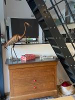 a wooden bird on top of a dresser next to a staircase at Le Mahonia in Yport