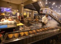 a chef preparing food in a restaurant kitchen at Hotel Kollol by J&Z Group in Cox's Bazar