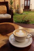 サン・クリストバル・デ・ラス・カサスにあるLa Estanciaの木製テーブルに座ってコーヒーを飲む