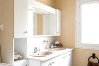 a bathroom with two sinks and a mirror at Villa de 4 chambres avec piscine privee jardin clos et wifi a Aytre a 5 km de la plage in Aytré