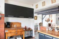 a kitchen with black cabinets and a wooden table at Villa de 4 chambres avec piscine privee jardin clos et wifi a Aytre a 5 km de la plage in Aytré