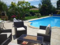 a swimming pool with two chairs and a table next to it at Villa de 4 chambres avec piscine privee jardin clos et wifi a Aytre a 5 km de la plage in Aytré