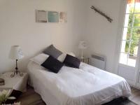a bedroom with a white bed and two windows at Villa de 4 chambres avec piscine privee jardin clos et wifi a Aytre a 5 km de la plage in Aytré