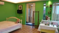 a bedroom with green walls and a bed with a teddy bear at Good Time B&amp;B in Jiufen