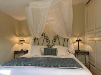 a bedroom with a large bed with white curtains at La Résidence du Moulin in Tourrettes-sur-Loup