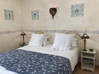 a bedroom with a bed with a blue and white comforter at La Résidence du Moulin in Tourrettes-sur-Loup