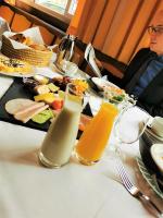 a table with a plate of food and two glasses of juice at Hotel König Ludwig in Altötting