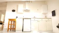 a white kitchen with white cabinets and a sink at Studio de charme en plein centre ville in Beauvais