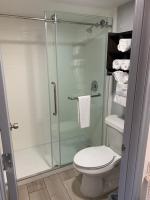 ein Badezimmer mit Toilette und Glasdusche in der Unterkunft South Padre Island Lodge in South Padre Island