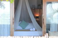 1 dormitorio con 1 cama con dosel y 2 toallas en Maligaya Beach Bungalows, en El Nido