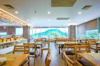 a restaurant with wooden tables and chairs and large windows at Vung Tau P&T Hotel in Vung Tau