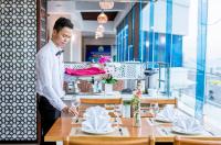 a man standing at a table in a restaurant at Vung Tau P&T Hotel in Vung Tau