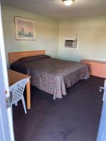 Una habitación de hotel con una cama, una mesa y un escritorio. en RAMONA MOTEL, en Hemet