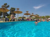 a group of people in a swimming pool with umbrellas at Mobile home De Luxe St Cyprien in Saint-Cyprien