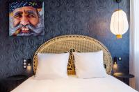 a bedroom with a bed with a portrait of an old man at Aiden by Best Western Lorient Centre in Lorient