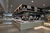 a restaurant with a counter with a lot of bottles of wine at Limak Skopje Luxury Hotel in Skopje