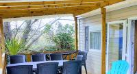 a patio with a table and chairs on a porch at Mobile home De Luxe St Cyprien in Saint-Cyprien