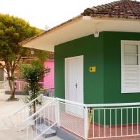 a green and white house with a white door at Pousada Mama África in Conservatória