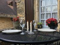 a black table with two glasses and candles on it at La Petite Maison in Beynac-et-Cazenac