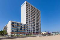 Un edificio alto con un cartel al costado. en Wyndham Virginia Beach Oceanfront, en Virginia Beach