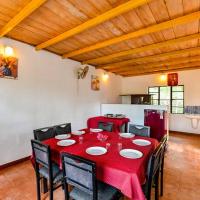 una sala da pranzo con tavolo e sedie rossi di Hill Rows Plantation and Forest Experience By GreenEscapes a Vythiri