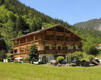 a large wooden house in the middle of a field at Haus Rätikon in Brand