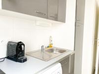 a white kitchen with a sink and a toaster at 003 - Appartement Moderne et Terrasse - Jeanne d&#39;Arc, Toulouse in Toulouse