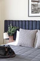 a bed with a blue headboard and a bag on it at Quest Echuca in Echuca