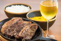 アラカジュにあるVidam Hotel Aracaju - Transamerica Collectionのステーキ一皿とワイン