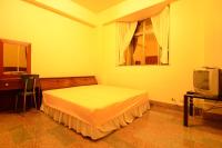 a bedroom with a bed and a television at Alishan Fenqihu Green Land Homestay in Guanghua