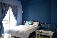 a bedroom with blue walls and a bed and a blue couch at Lane Homestay in Dayin