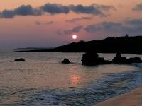 a sunset over the ocean with rocks in the water at 海灘戀情 Beach Love 近沙灘-國旅卡特約商店 in Eluan