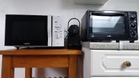 a microwave and a television on top of a counter at Studio de charme en plein centre ville in Beauvais
