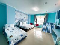 a blue bedroom with two beds and a crib at 恆春古城親子民宿 in Hengchun South Gate