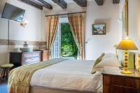 a bedroom with a bed and a window at Au Moulin de La Gorce in La Roche-lʼAbeille