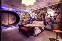 a bedroom with a bed and a chair and purple lighting at Icloud Luxury Resort &amp; Hotel in Taichung