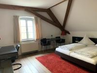 1 dormitorio con cama, escritorio y alfombra roja en Buhlsche Mühle, en Ettlingen