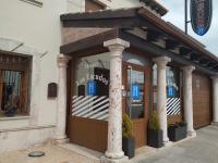 un frente de tienda con pilares delante de un edificio en Hostal Los Escudos, en Almagro